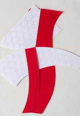 red and white paper strips woven together into a unit