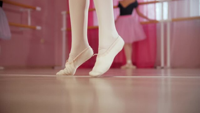 Three ballerina girls in beautiful tutu in the ballet studio - one of them starts dancing