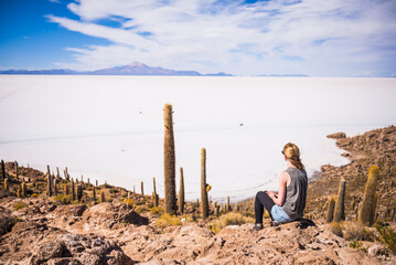 Tourist on cactus covered Fish Island (Isla Incahuasi or Inka Wasi), Uyuni Salt Flats (Salar de Uyuni), Uyuni, Bolivia, South America - obrazy, fototapety, plakaty
