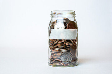 glass jar of change/ money with white blank tape label