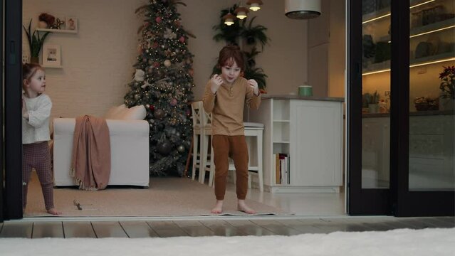 cheerful kids opening sliding doors in modern apartment at winter day