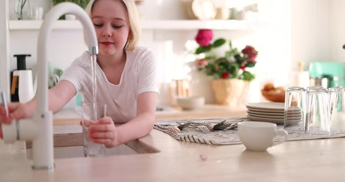 young boy pouring a tap water in glass, pure drinking water