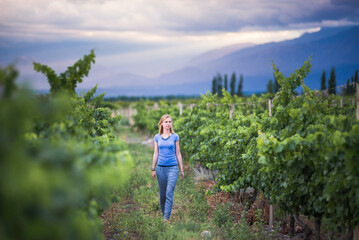 Woman in vineyards in Andes mountains on wine tasting vacation at a winery in Uco Valley (Valle de Uco), a wine region in Mendoza Province, Argentina, South America