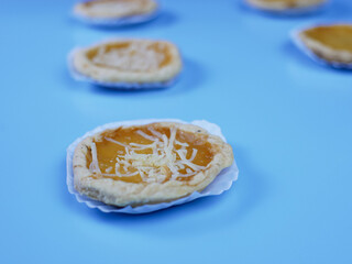 Pineapple and cheese flavored pie on blue background