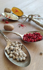 Seasonings and spices in antique spoons. Pepper. Turmeric.
