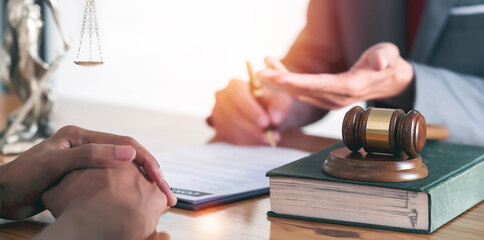 Lawyer Legal counsel presents to the client a signed contract with gavel and legal law book....