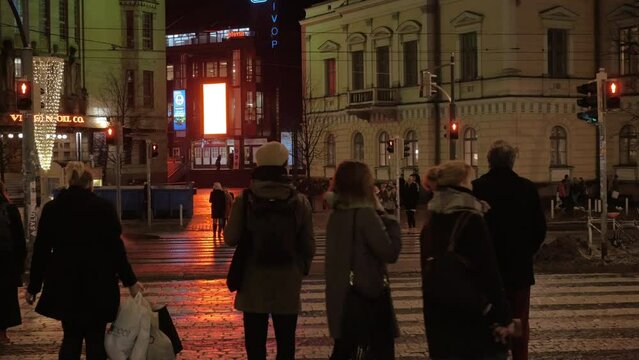 People crossing the road in night city. Helsinki, Finland