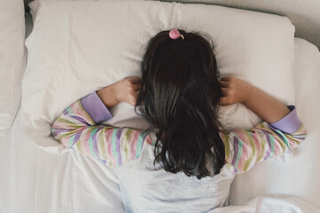 Girl covering ears with his fingers in bed, ADHD, sleep disorder, mental health in children, not...