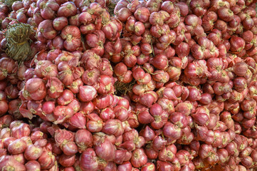 A Pile of red onion for sale at a local farmers market in thailand, natural herb,  shallot is the spices cooking  from the garden, vegetables for health,