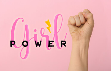 Hand of woman with clenched fist and text GIRL POWER on color background. International Women's Day...