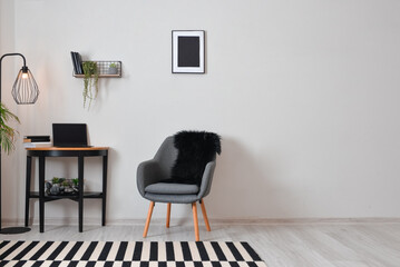 Stylish interior of minimalist room with modern workplace and laptop