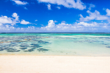Fototapeta na wymiar Tropical white sandy beach, perfect clear blue turquoise water and clear blue sky on a paradise island in the Pacific Ocean in Muri area of Rarotonga, Cook Islands, background with copy space