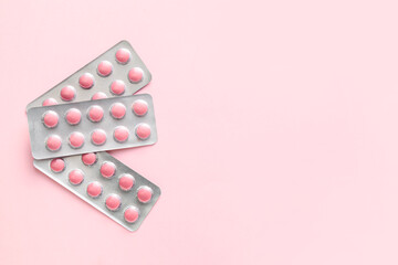 Blister packs with pills on pink background