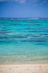 Kayaking in the beautiful blue tropical ocean of Titikaveka Lagoon, Rarotonga, Cook Islands background with copy space