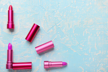 Clock made of lipsticks on color background