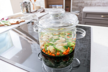 Cooking pot with healthy vegetables on electric stove in kitchen