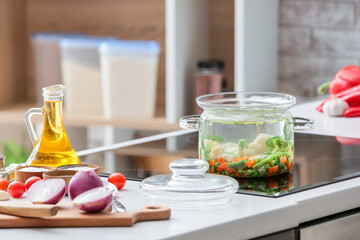 Cooking pot with tasty dietary soup on electric stove in kitchen