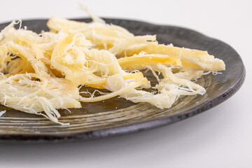 黒いお皿にのせられたさきいか　Dried fish
