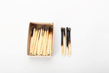 Matchbox and burnt out matches on white background. Concept of work burnout