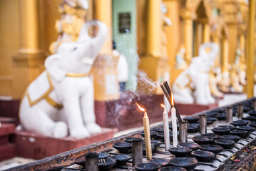 Burning prayer candles at Shwedagon Pagoda (aka Shwedagon Zedi Daw or Golden Pagoda), Yangon (Rangoon), Myanmar (Burma)