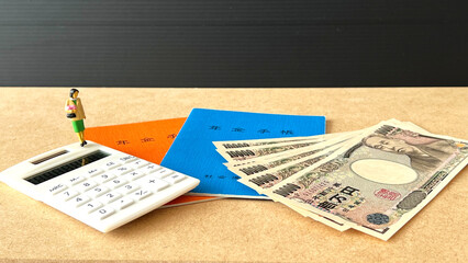 高齢女性のミニチュアと年金手帳と計算機とお金