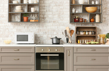 Interior of kitchen with modern microwave oven and kitchenware