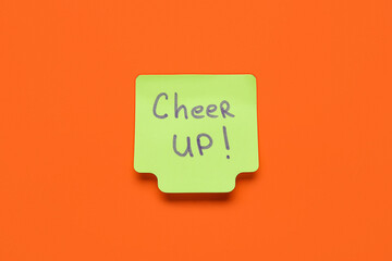 Sticky note with text CHEER UP on red background