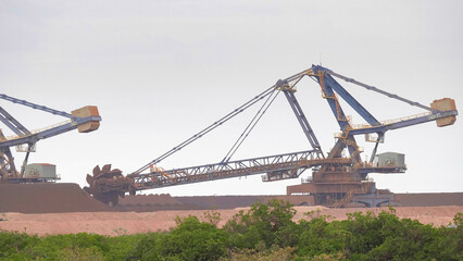 Fototapeta na wymiar an iron ore stacker loader in operation at port hedland