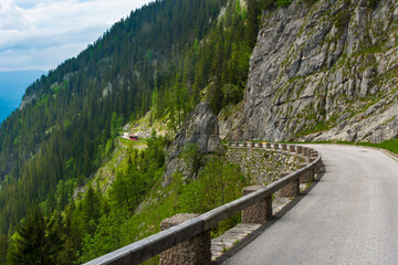 red bus driving on a road in the mountains