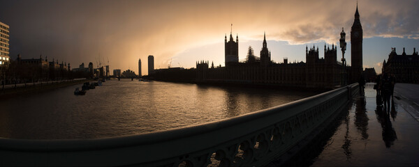 Naklejka premium Houses of Parliament (Palace of Westminster) and Big Ben silhouetted at sunset, seen from Westminster Bridge, London, England