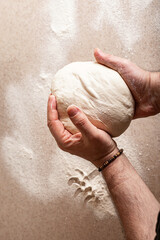 Male hands knead the dough. Human hands preparing dough for homemade baguette. Top view. Vertical shot