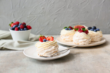 Plates of tasty Pavlova cakes with fresh berries on table