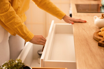 Woman opening empty kitchen drawer, closeup