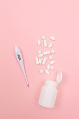 White Pills or Tablets with Electronic Thermometer on Pink Background. Pharmaceutical Industry and Medicinal Products
