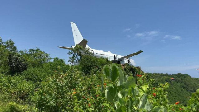 A beautiful live camera footage of whiteabandoned airplane on a high cliff near the ocean shore. Broken aircraft at Nyang Nyang beach in Bali island.