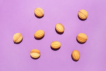 Tasty walnut shaped cookies with boiled condensed milk on color background
