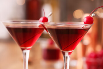 Glasses of tasty Manhattan cocktail on blurred background, closeup