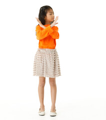 Full body cutout isolated studio shot of Asian young primary schoolgirl model in casual orange shirt and skirt outfit standing on white background