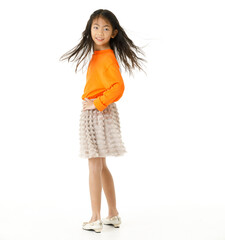 Full body cutout isolated studio shot of Asian young primary schoolgirl model in casual orange shirt and skirt outfit standing on white background