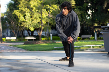 young athlete stretching his muscles while training outdoors in the park