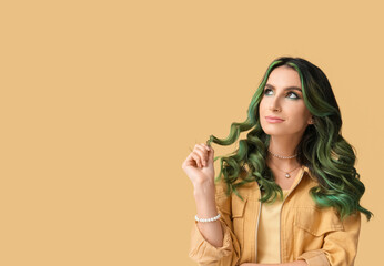 Beautiful young woman with unusual green hair on color background