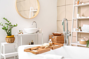 Wooden tray with accessories on bathtub in modern room