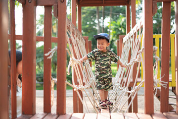 Asian boy in military suit playing and having fun at kid training playground