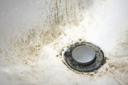 Dirty sink drain or wash mesh hole with rust and grunge.