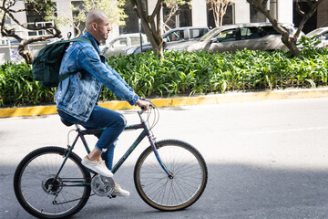 Obraz premium Bald young man dressed casual riding a bike in the city