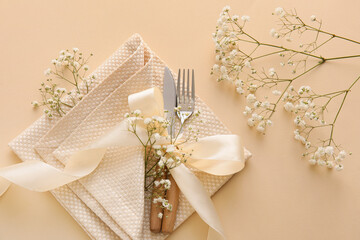 Stylish cutlery with flowers on yellow background