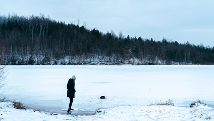 Woman taking a walk through the forest on a cold winters day