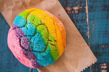 Colorful Rainbow Concha Mexican Pastry on a Paper Bag. A sweet bread with a Heart Shape for LGBT...