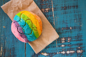 Colorful Rainbow Concha Mexican Pastry on a Paper Bag. A sweet bread with a Heart Shape for LGBT...