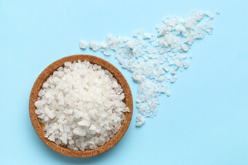 Bowl of sea salt on color background